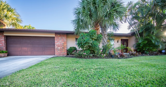 single story home with a garage and a front lawn