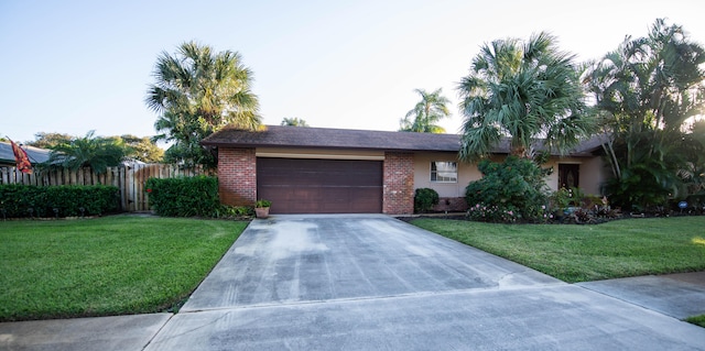 ranch-style house with a garage and a front lawn