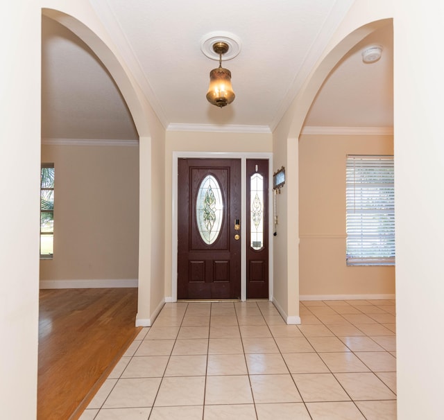 entrance foyer with crown molding and light hardwood / wood-style floors