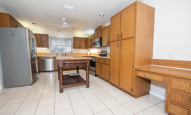 kitchen with backsplash, stainless steel appliances, ceiling fan, sink, and light tile patterned floors