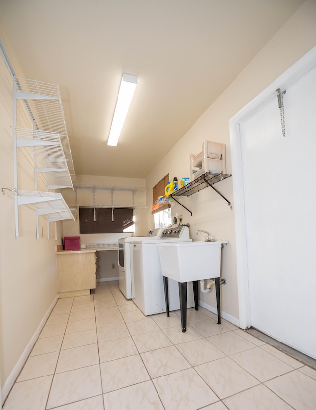 laundry room featuring light tile patterned floors, sink, and washing machine and clothes dryer