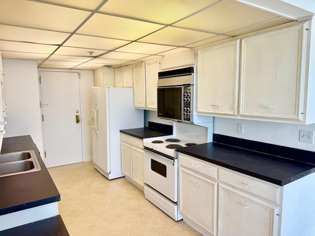 kitchen featuring a drop ceiling, sink, and white appliances