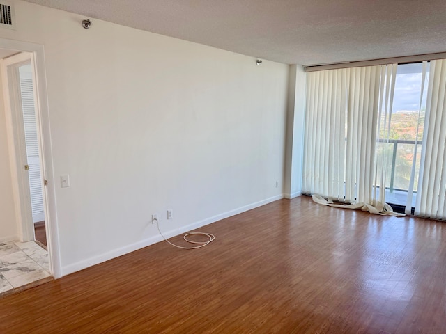 empty room with a textured ceiling and hardwood / wood-style floors