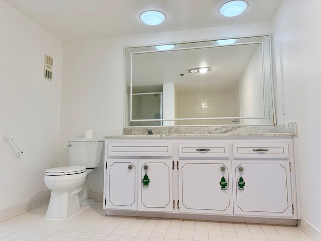 bathroom featuring toilet, vanity, tile patterned flooring, and a shower