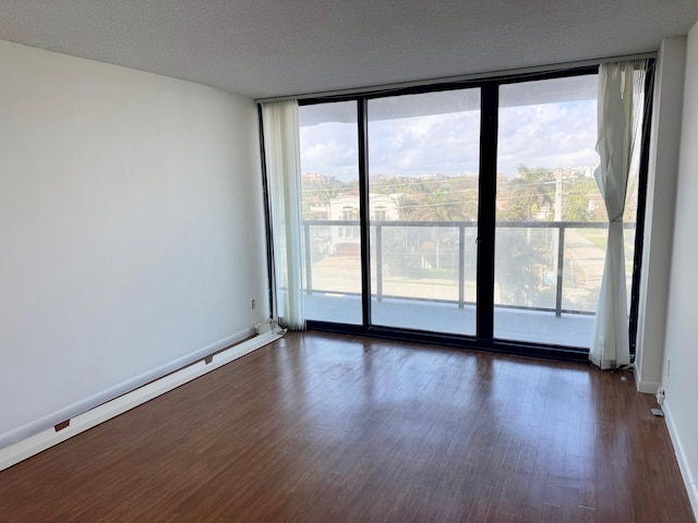 spare room featuring a textured ceiling, dark hardwood / wood-style floors, and expansive windows