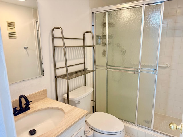 bathroom featuring an enclosed shower, vanity, and toilet