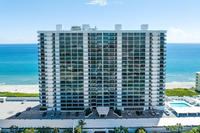 view of building exterior featuring a water view and a view of the beach