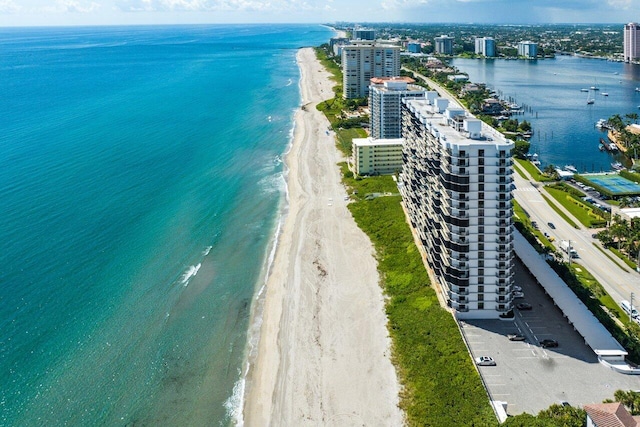 birds eye view of property with a water view and a beach view