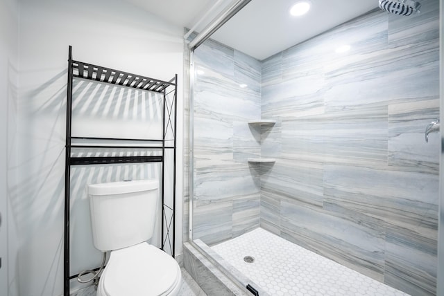 bathroom featuring toilet and a tile shower