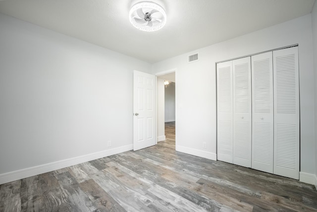 unfurnished bedroom with a closet and hardwood / wood-style flooring