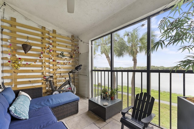 sunroom with ceiling fan and vaulted ceiling