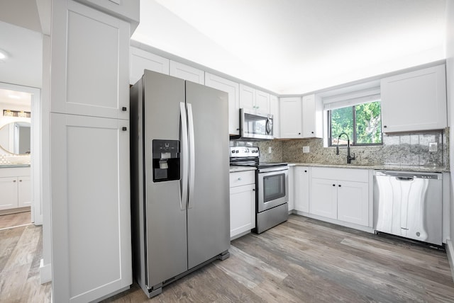 kitchen with appliances with stainless steel finishes, white cabinetry, and sink