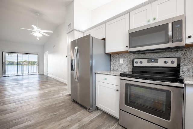 kitchen with lofted ceiling, white cabinets, ceiling fan, and appliances with stainless steel finishes