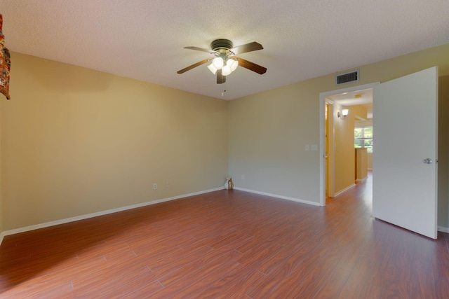 unfurnished room featuring ceiling fan, a textured ceiling, and dark hardwood / wood-style floors