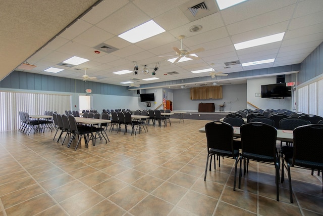 tiled dining space featuring a paneled ceiling and ceiling fan