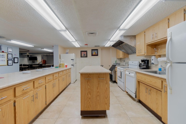 kitchen featuring a textured ceiling, sink, light tile patterned flooring, a kitchen island, and white appliances