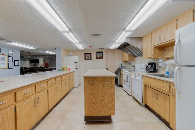 14 Lake Vista Trl Unit 104, Port Saint Lucie, FL 34952 - kitchen featuring white appliances, a center island, a sink, a textured ceiling, and light countertops