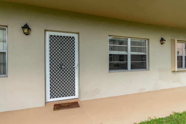 14 Lake Vista Trl Unit 104, Port Saint Lucie, FL 34952 - doorway to property with stucco siding and a patio area