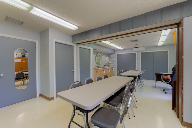 dining room with a textured ceiling and a wall mounted AC