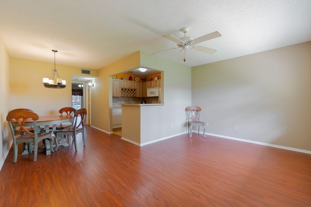 interior space with ceiling fan with notable chandelier, a textured ceiling, and dark hardwood / wood-style flooring