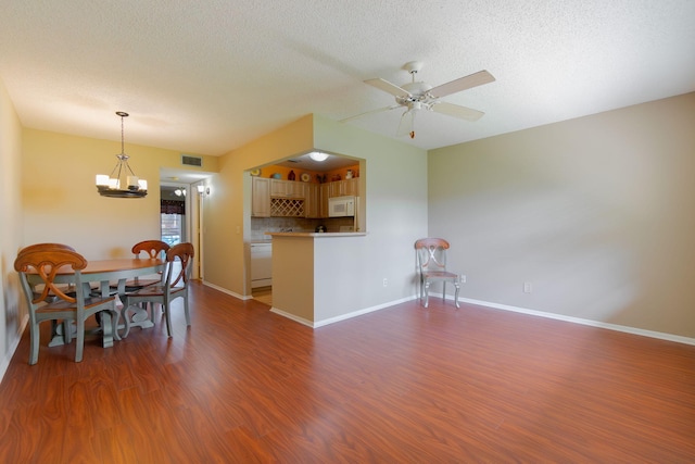 14 Lake Vista Trl Unit 104, Port Saint Lucie, FL 34952 - dining space with ceiling fan, wood finished floors, a chandelier, a textured ceiling, and baseboards
