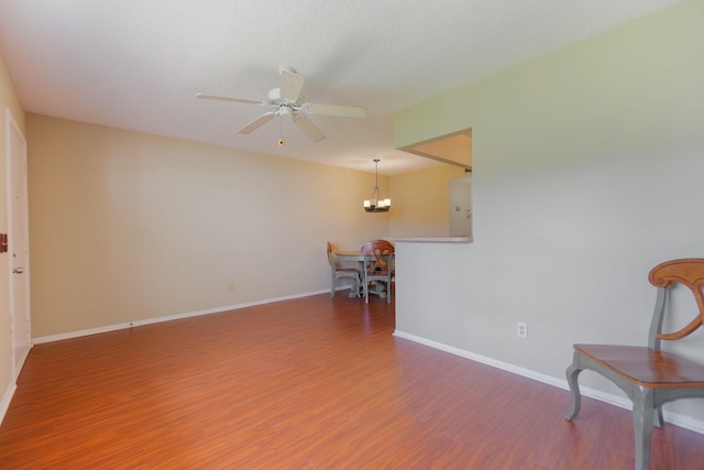 sitting room featuring wood-type flooring, a textured ceiling, and ceiling fan with notable chandelier