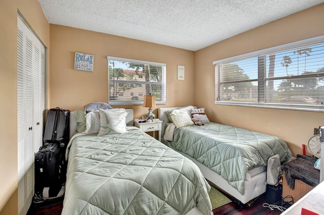 bedroom featuring wood-type flooring, a textured ceiling, and a closet