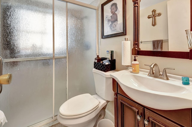 bathroom featuring vanity, toilet, and a shower with door