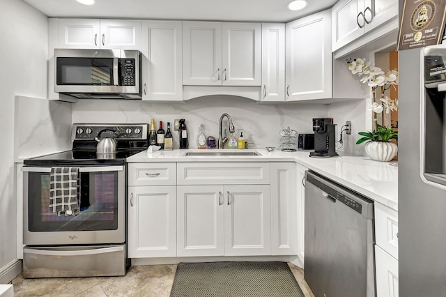 kitchen featuring white cabinetry, sink, light tile patterned flooring, and stainless steel appliances