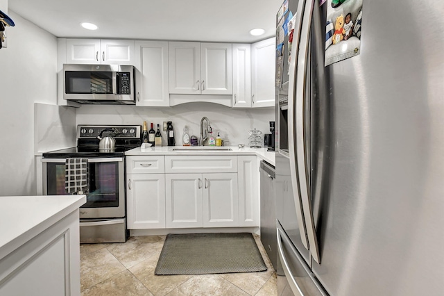 kitchen featuring sink, white cabinets, stainless steel appliances, and light tile patterned floors