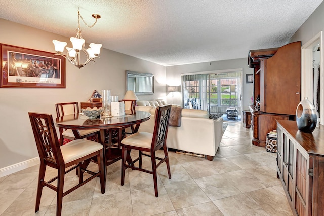 dining area with a notable chandelier, light tile patterned floors, and a textured ceiling