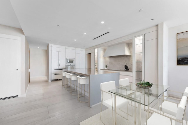 kitchen featuring white cabinets, tasteful backsplash, and white appliances