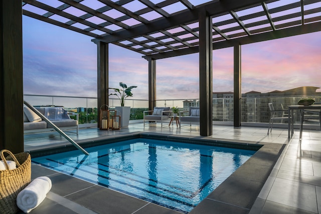 pool at dusk featuring a pergola and a patio area