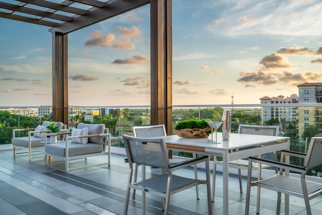 balcony at dusk with outdoor lounge area and a pergola