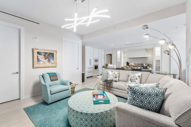 living room with light wood-type flooring and a chandelier