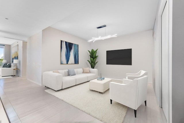 living room with light hardwood / wood-style flooring and an inviting chandelier