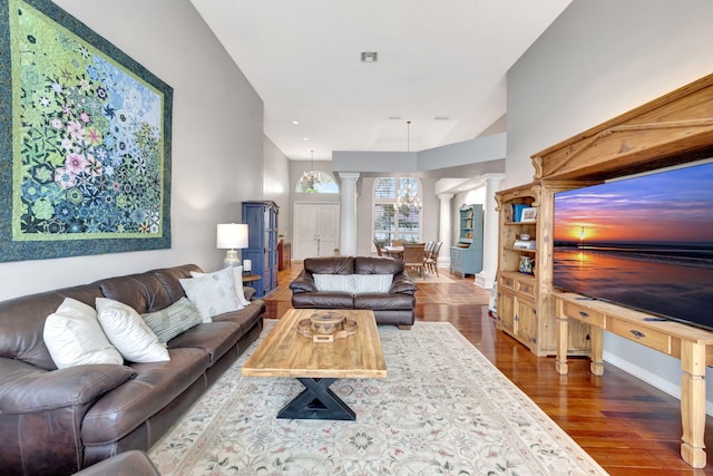 living room featuring ornate columns and dark hardwood / wood-style floors