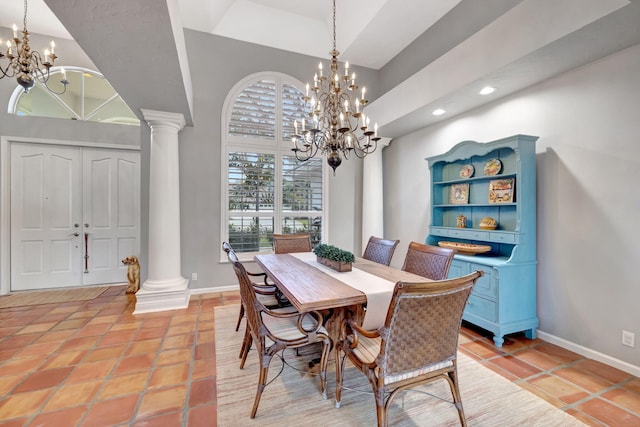 tiled dining area with a chandelier, a high ceiling, and ornate columns