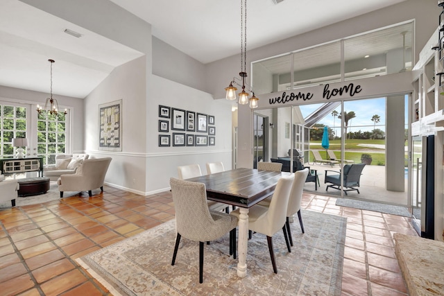 tiled dining space with a notable chandelier and vaulted ceiling