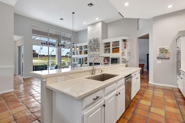 kitchen with white cabinets, a kitchen breakfast bar, sink, and high vaulted ceiling