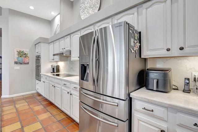 kitchen with light stone countertops, stainless steel appliances, light tile patterned floors, tasteful backsplash, and white cabinets