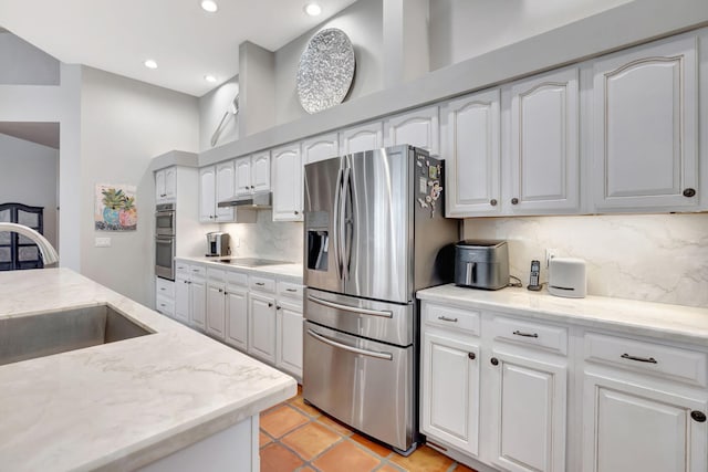 kitchen featuring stainless steel appliances, white cabinetry, tasteful backsplash, and sink