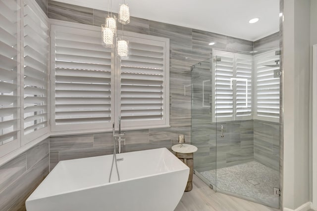 bathroom featuring separate shower and tub and tile walls