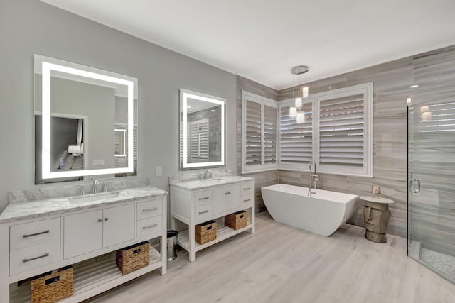 bathroom featuring hardwood / wood-style floors, vanity, tile walls, and independent shower and bath