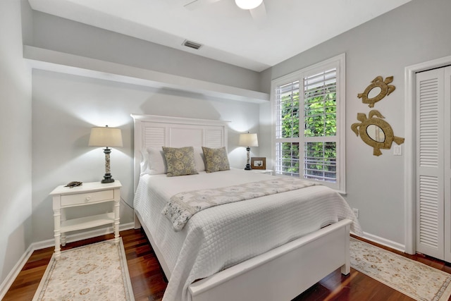 bedroom with ceiling fan, dark wood-type flooring, and a closet