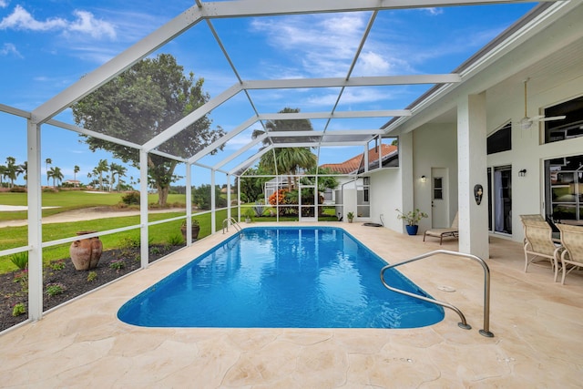 view of pool featuring a patio, glass enclosure, and a lawn