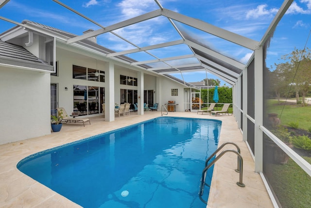 view of pool with a patio and glass enclosure