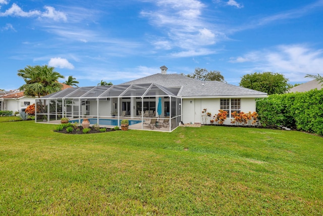 back of property featuring a lawn and a lanai