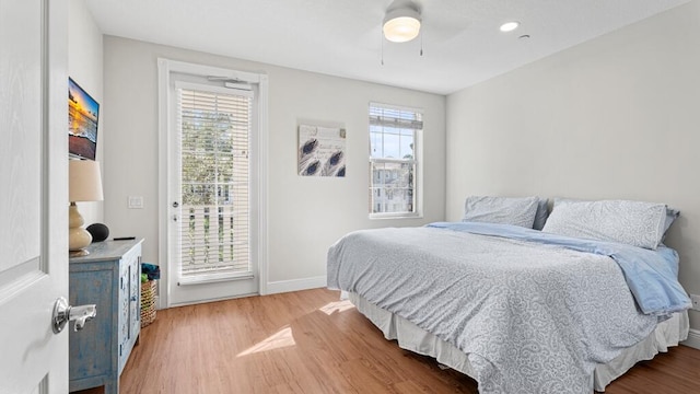 bedroom with multiple windows, wood-type flooring, and ceiling fan