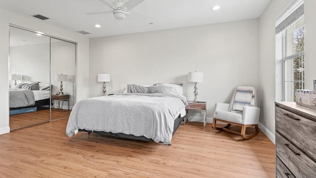 bedroom with a closet, light hardwood / wood-style floors, and ceiling fan